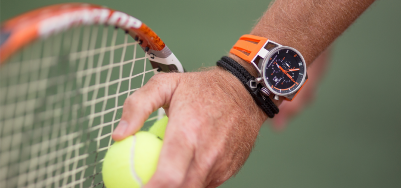 Man playing tennis wearing Trion:Z bracelet